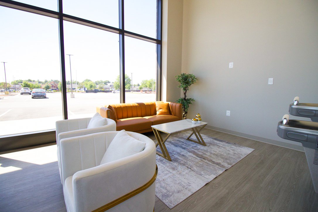 Waiting area at Manassas Dental & Cosmetics with leather sofa and floor-to-ceiling windows